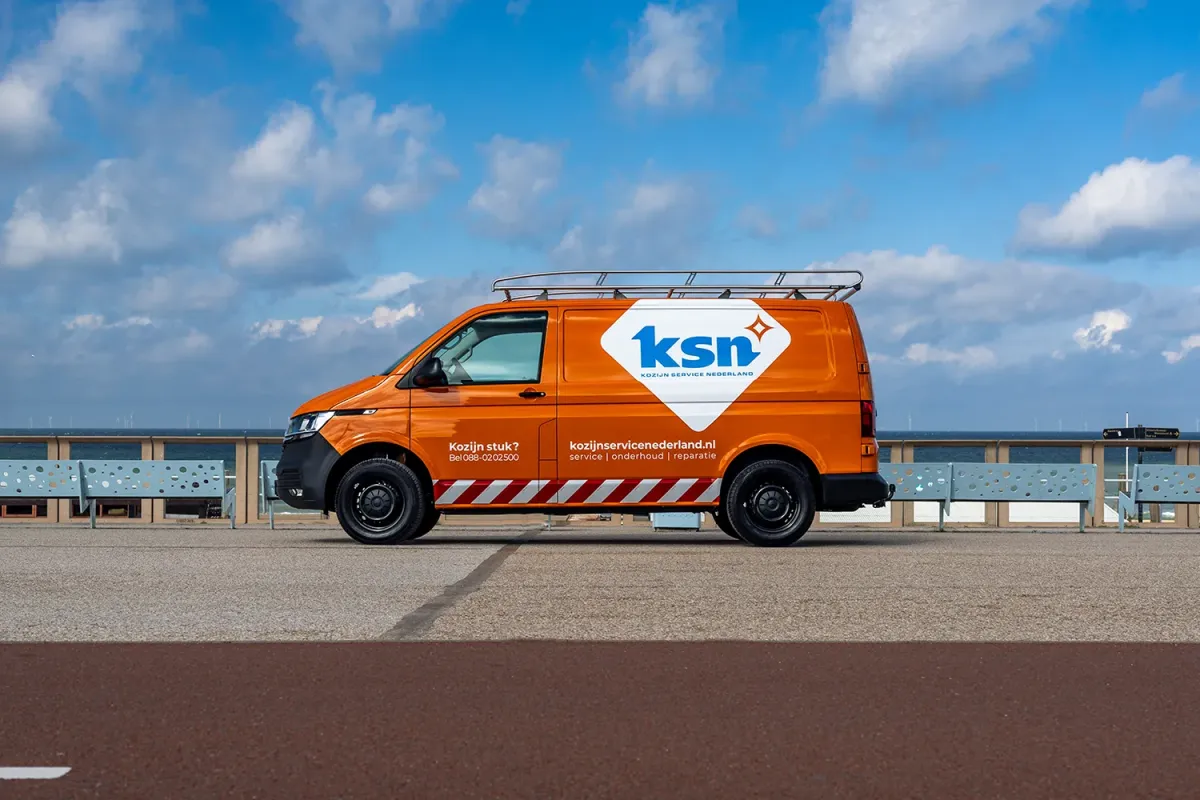 Opvallende oranje KSN bus bij het strand