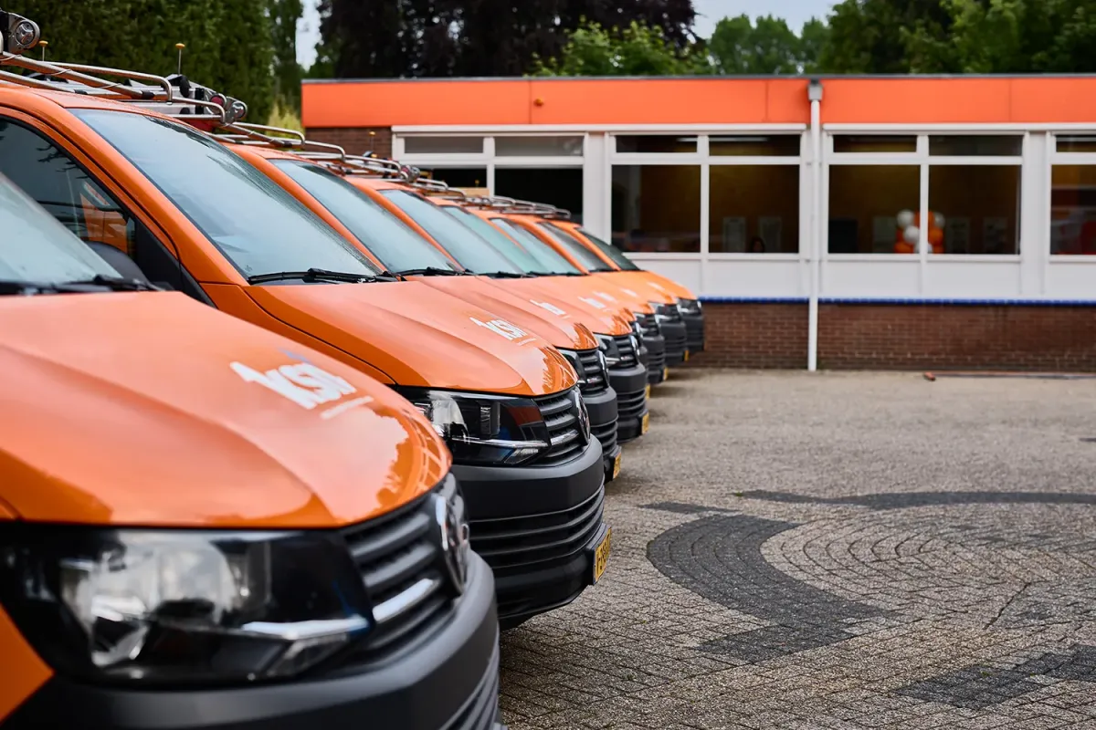 Rij van oranje KSN bussen bij hoofdkantoor en magazijn in Wassenaar