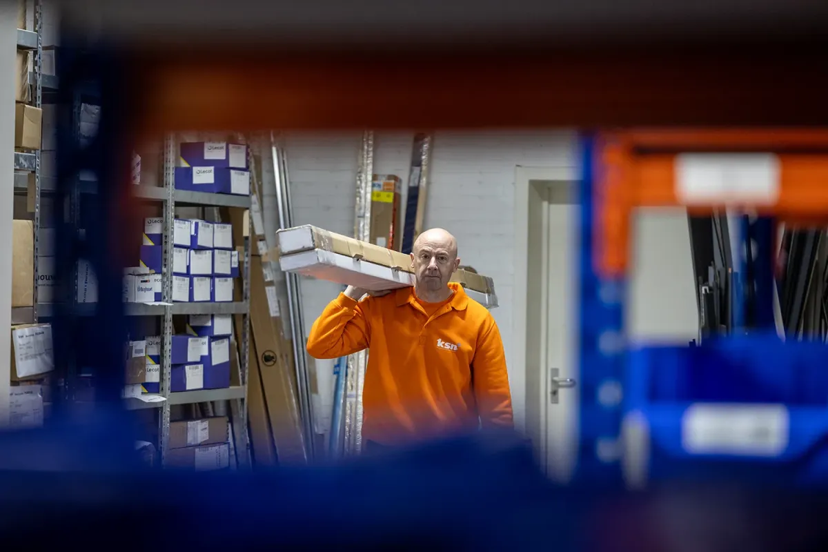 Collega met kozijnonderdelen bij magazijn van KSN