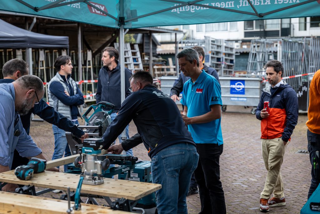 Meerder monteurs die de makita booormachine gereedschap uitproberen