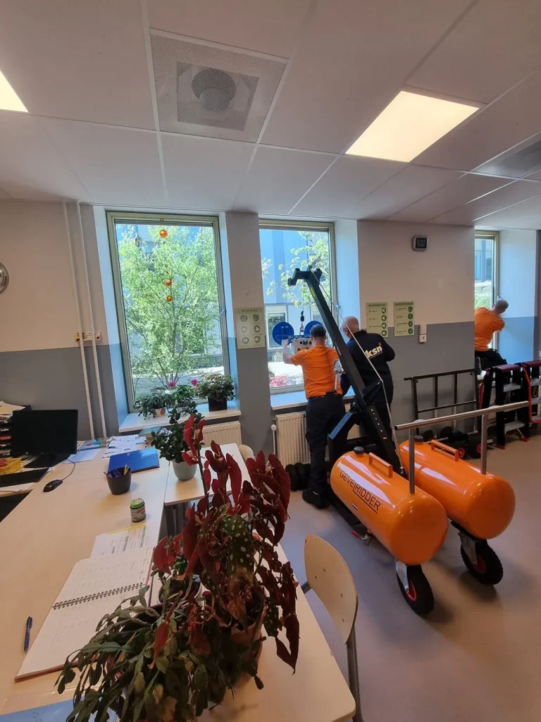 Monteurs werken met een glastilhulp om veilig te werken.